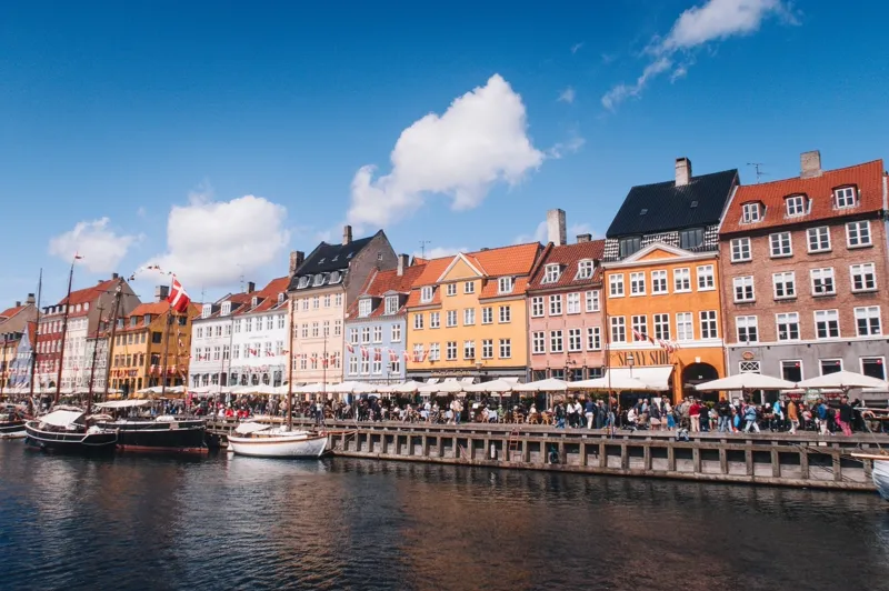 Nyhavn waterfront with colorful historic buildings and boats in Copenhagen - popular tourist attraction near course location